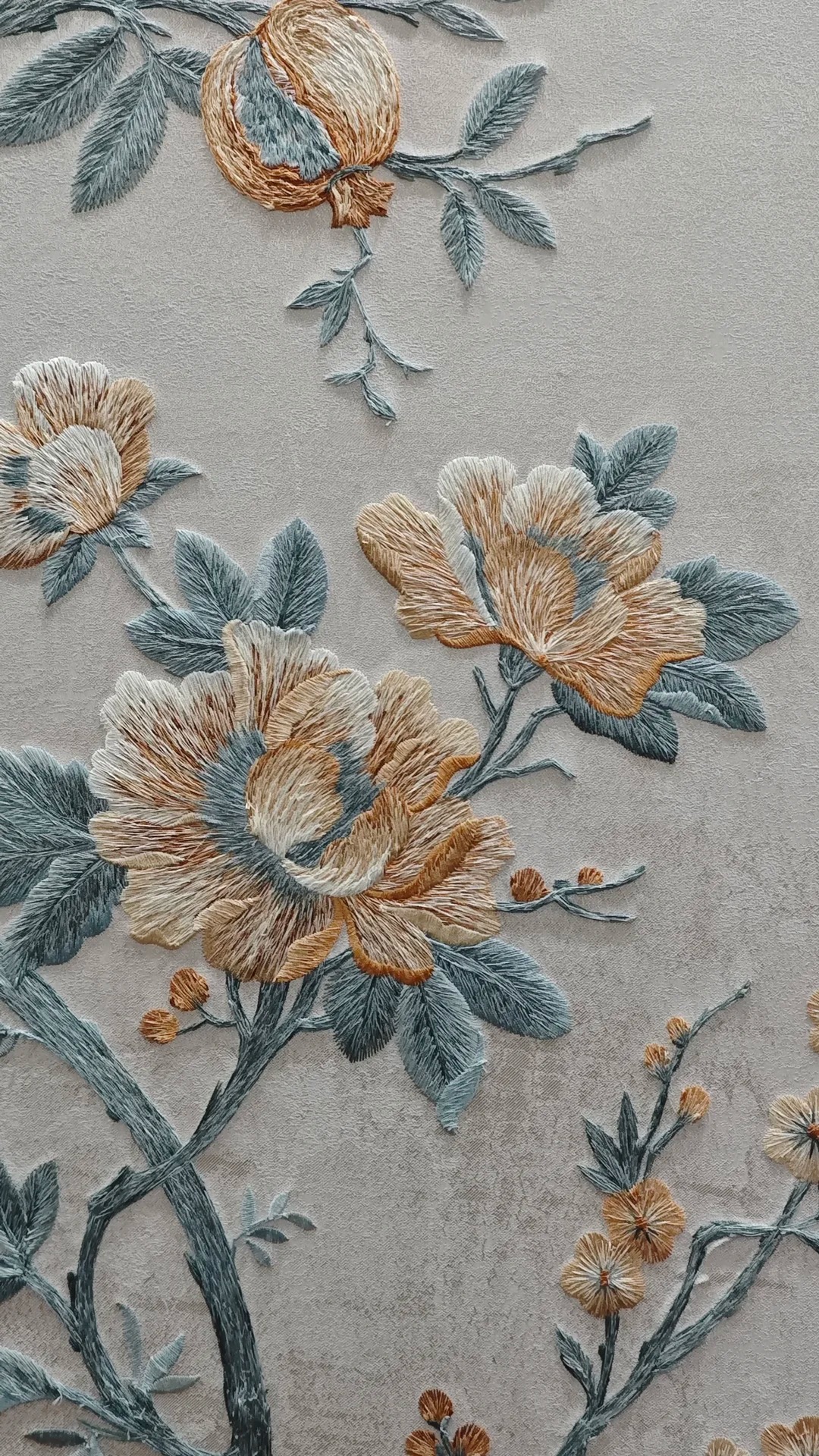 Close-up of floral embroidered wallcovering with soft blue leaves